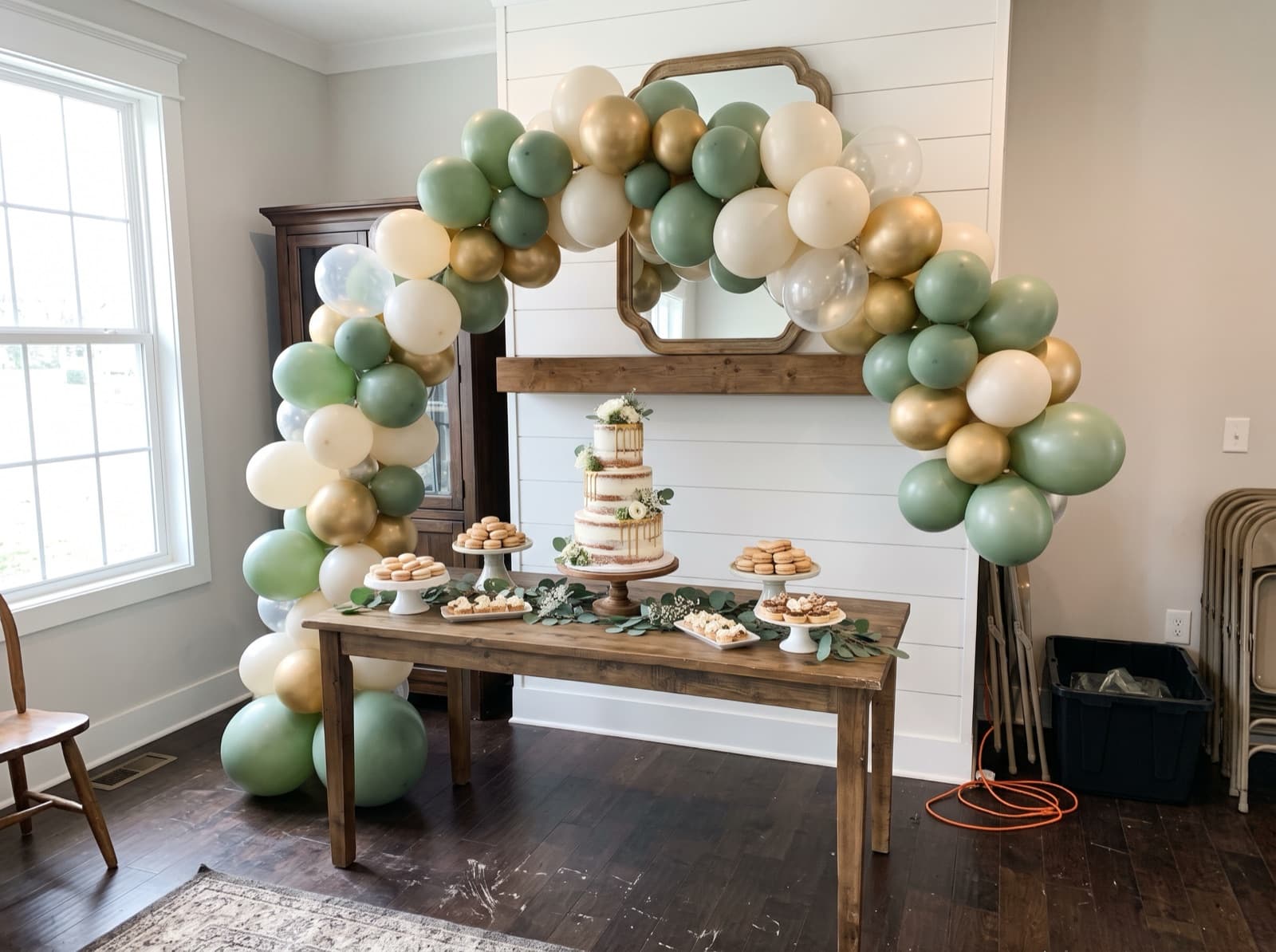Organic balloon arch in sage, ivory and gold over a dessert table